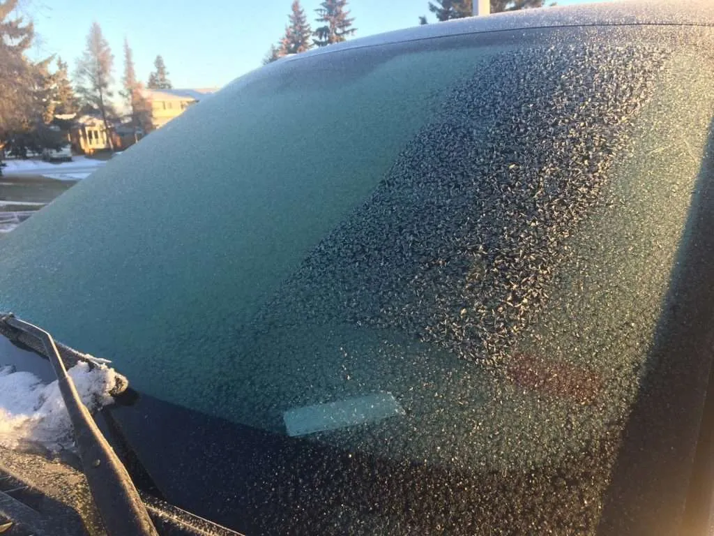 Close-up on a windshield covered in a layer of frost