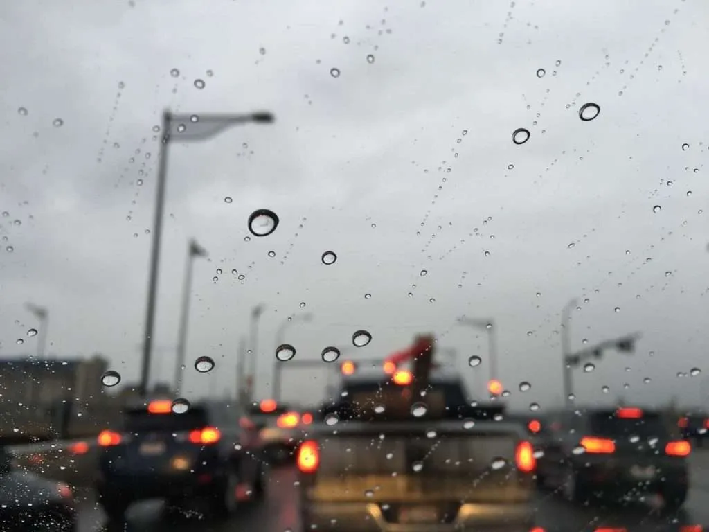 Close-up on water droplets beading off a windshield treated with Nano Coating