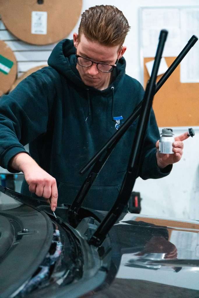 Windshield Surgeons technician completing the application of polyurethane adhesive for auto glass replacement