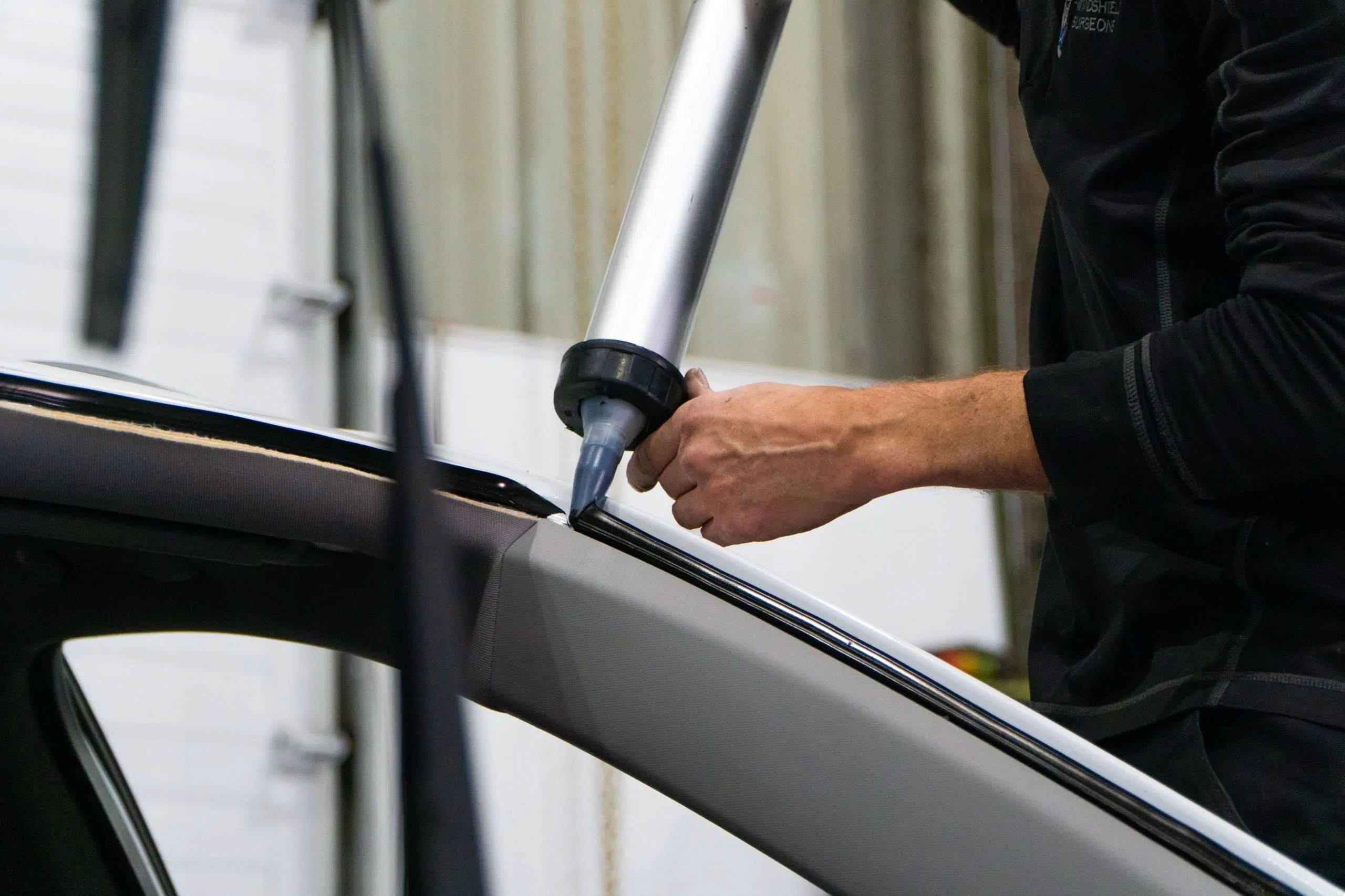 Windshield Surgeons technician applying urethane to a frame