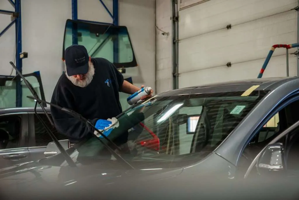 Windshield Surgeons Technician cleaning a freshly replaced windshield