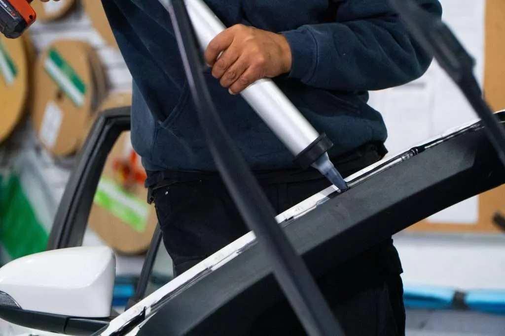 Windshield Surgeons technician applying urethane adhesive during a windshield replacement