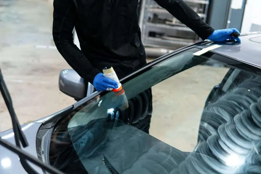 Close-up on a Windshield Surgeons technician applying nano-coating to a car's windshield