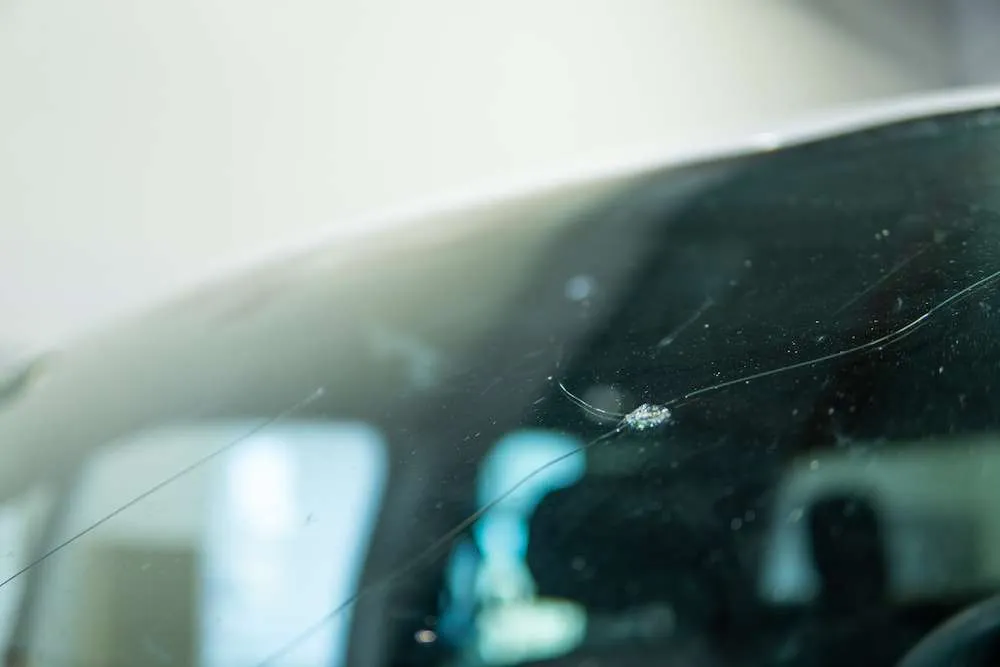 Close-up of a windshield with a rock chip and crack spreading outward