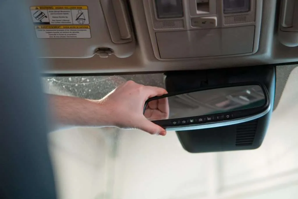 a hand holding a mirror in a car