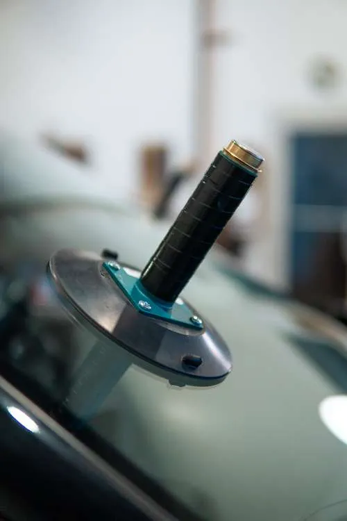Close-up of a windshield suction grip tool used during professional auto glass installation