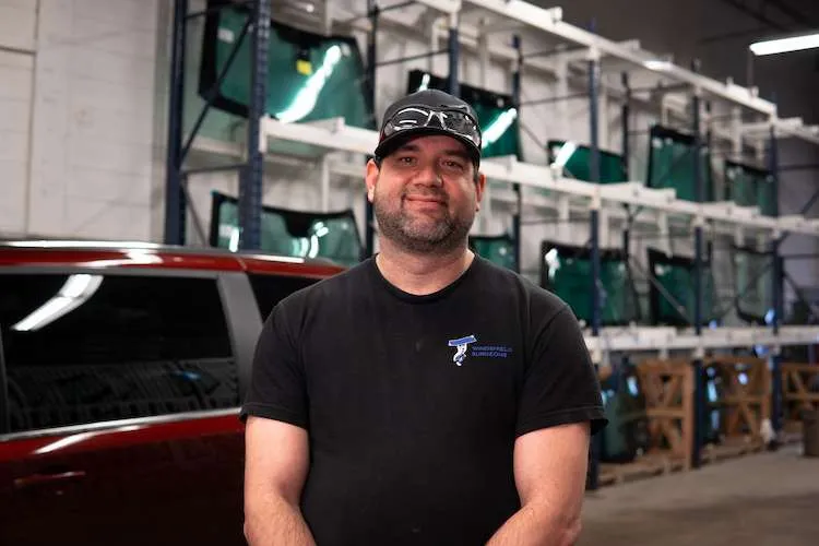 Windshield Surgeons Auto Glass technician posing for a photo inside our Red Deer location