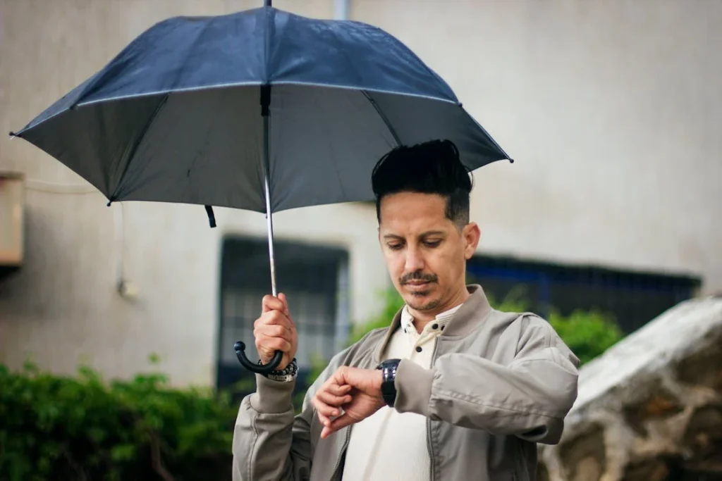 A person standing under an umbrella to avoid rain