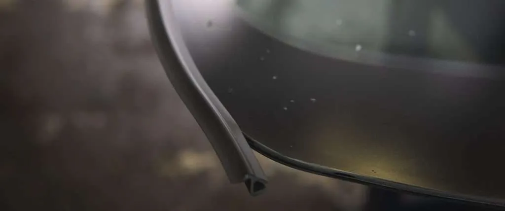 Close-up photo of a windshield with a separate gasket style moulding around the glass edge