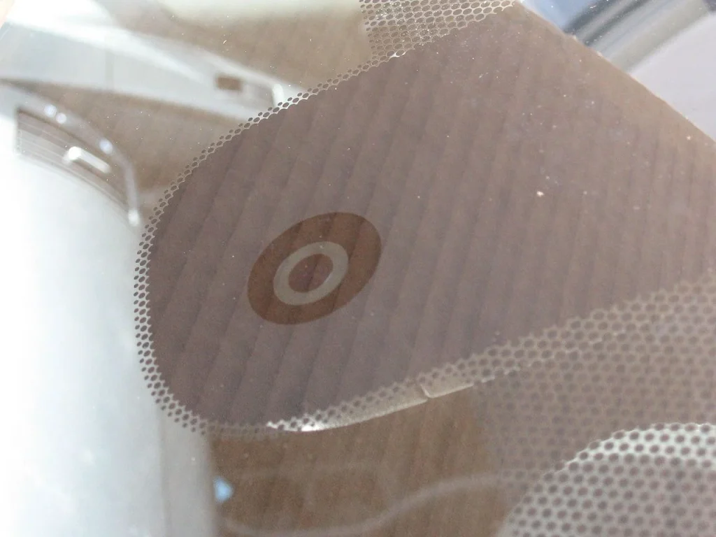 Close-up of a vehicle windshield rain sensor used for automatic wiper activation