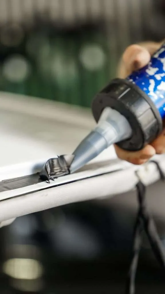 Extreme close up on the application of urethane for a new windshield installation.