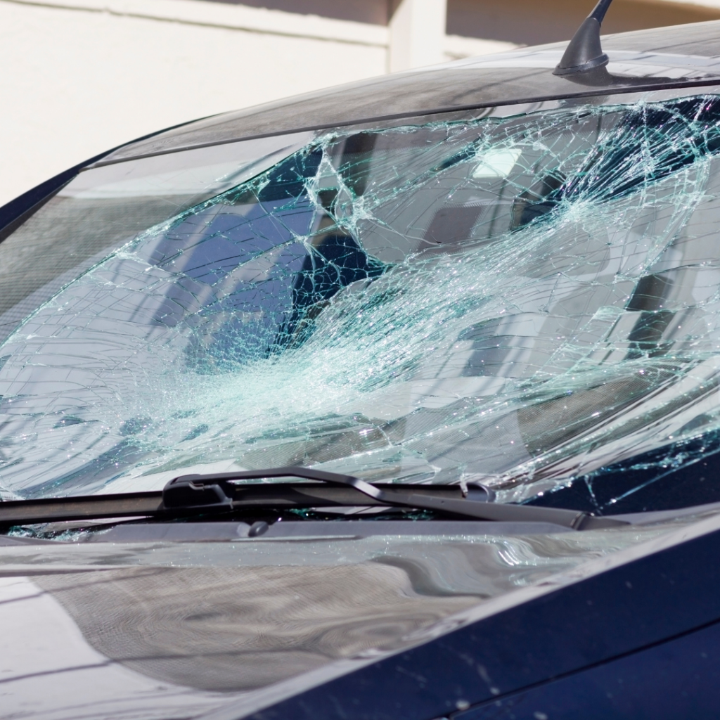 Broken windshield with heavy damage that illustrates how laminated safety glass stays together when broken