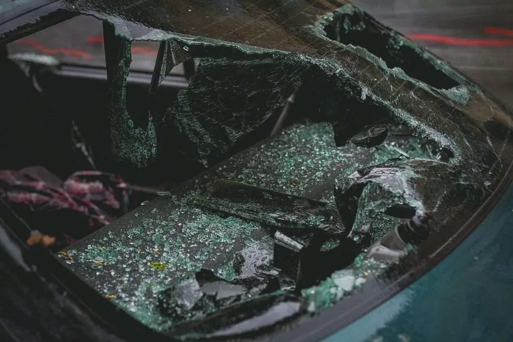 A vehicle's broken rear window glass that showcases the tiny shards that result from tempered glass shattering